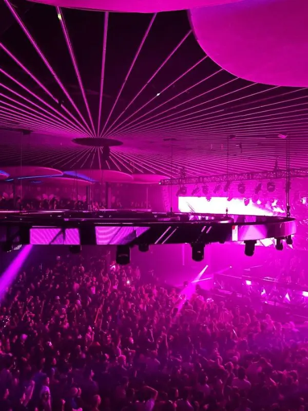 A crowded dance floor with purple lights at Rebel nightclub in Toronto.