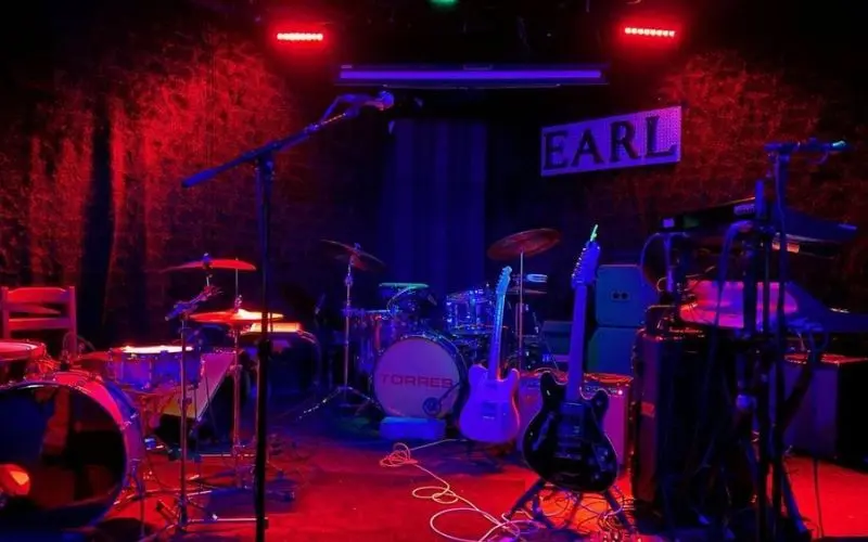 Stage setup with drums and guitars at The Earl.