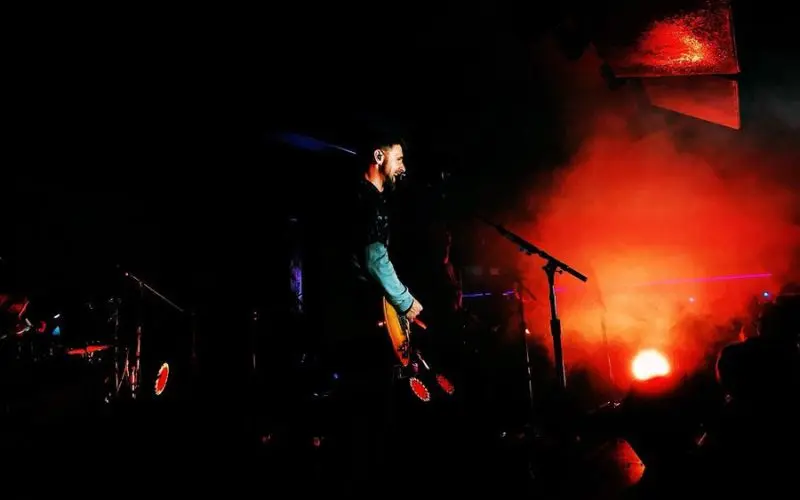 A musician performs under red stage lights at Club Rodeo.