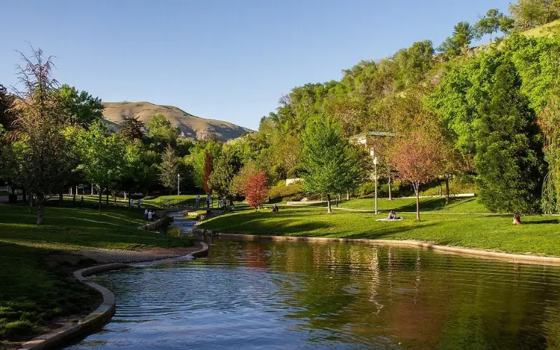 Salt Lake City Utah park with stream, trees, and foothills.
