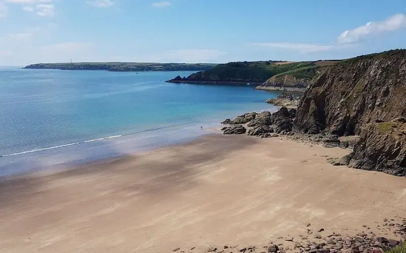 Empty sandy cove with cliffs at Pembrokeshire Coast National Park.