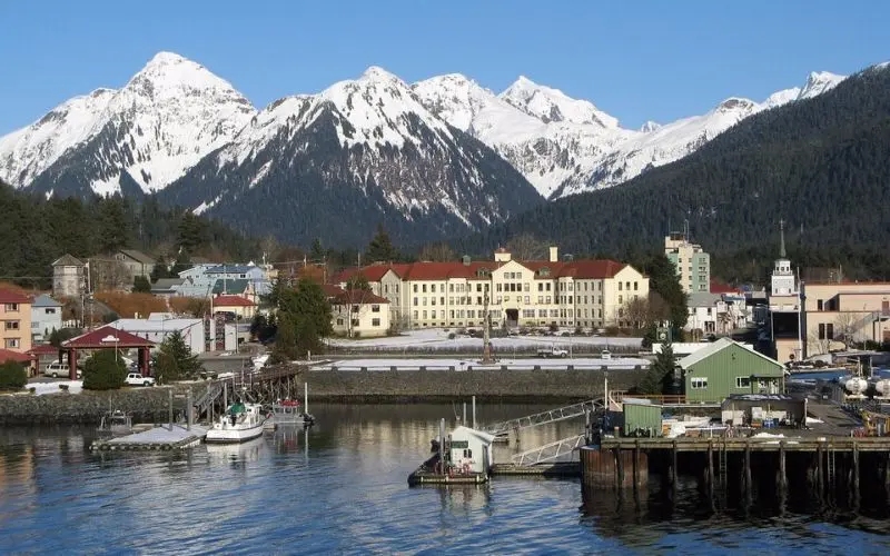 Waterfront town of Sitka with snowy mountains in the background.