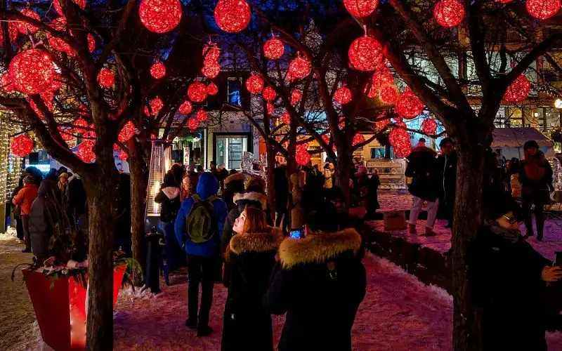People enjoying festive lights and decorations in Yorkville, Toronto.