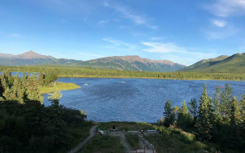 Blue lake and forested hills under clear skies in Wasilla.