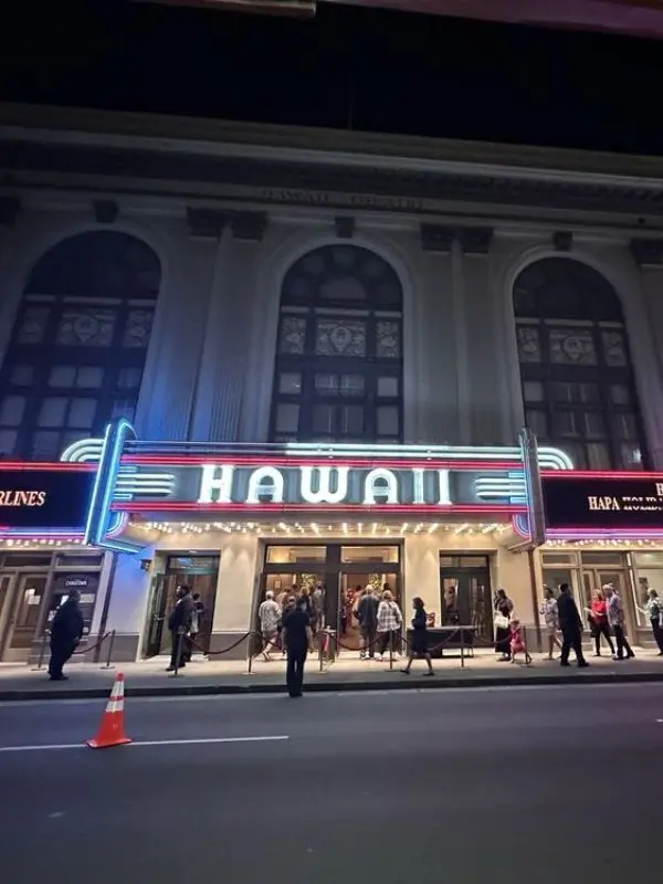Neon-lit entrance of the Hawaii Theater at night.