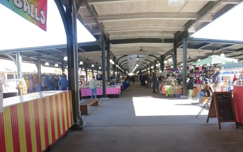French Market with stalls selling goods along a covered walkway.