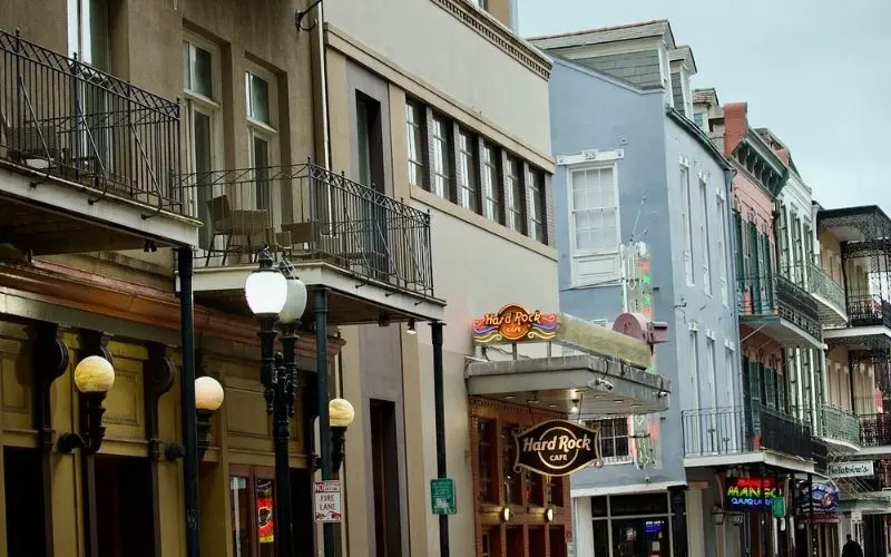 Bourbon Street with colorful buildings and balconies lined with street lamps.