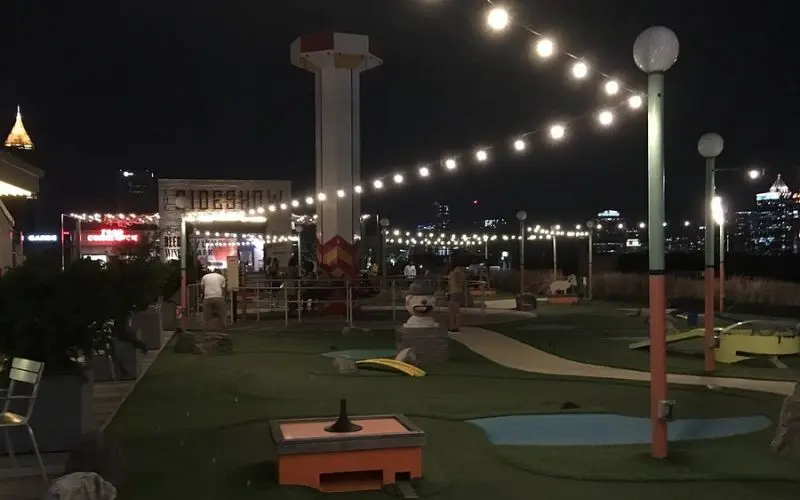 Rooftop mini golf under string lights at Skyline Park.