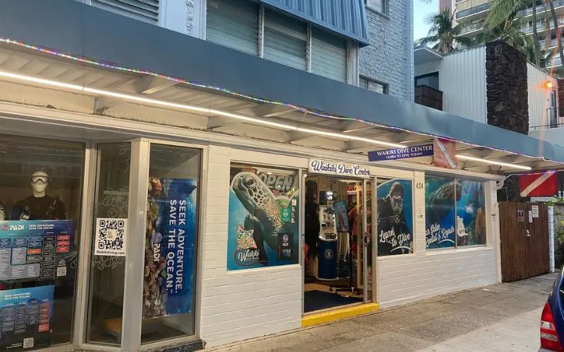 Exterior of Waikiki Dive Center with posters and dive gear.