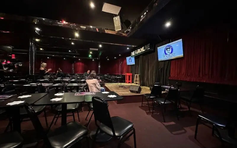 Comedy stage with tables and chairs at The Punchline.