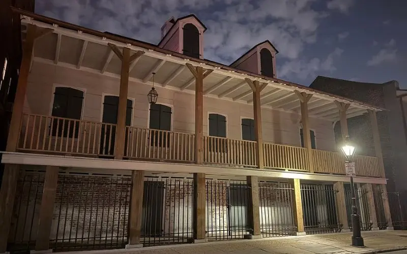Haunted Ghost Tours with a historic two-story building lit at night.