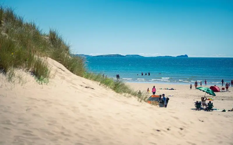 Sandy beach with families and umbrellas at Pembrey Country Park.