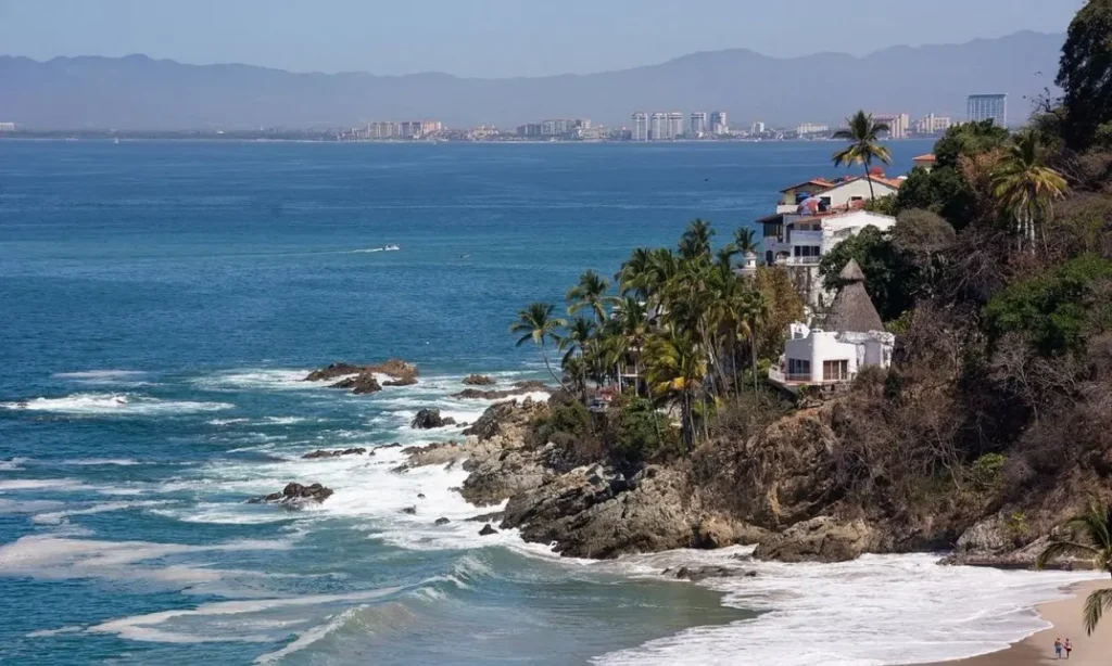 Ocean view with rocky coastline and buildings in Puerto Vallarta.