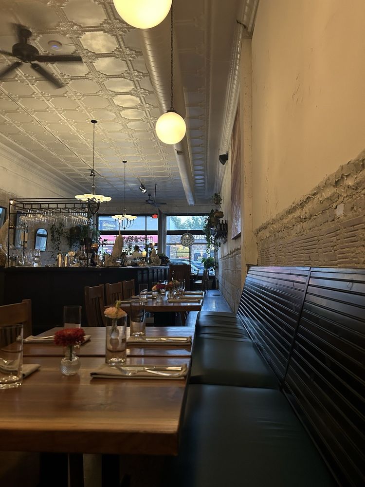 Cozy, upscale dining room with wooden tables and elegant lighting at Au Courant.