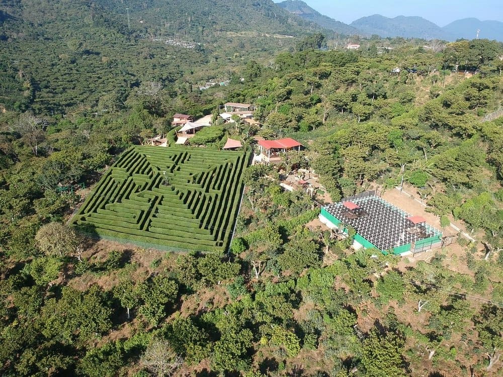 Aerial view of Café Albania with its large green hedge maze in the mountains.