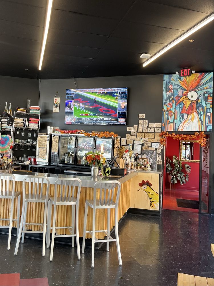 Lively bar area with bold artwork and a TV showing sports at Dirty Birds.