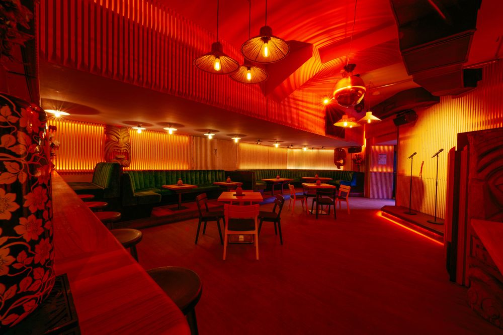 Enter The Dragon Restaurant’s vibrant, red-lit interior with stage setup.