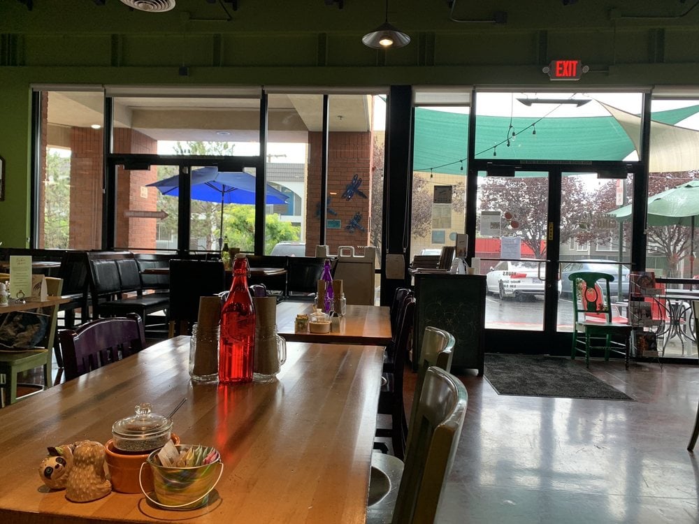 Cozy and eclectic dining area at Great Full Gardens – Midtown with colorful decor and large windows.