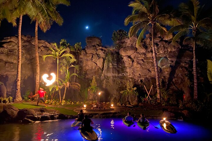 Lunar Legends Night Paddle with kayakers watching fire dancing under moonlight.