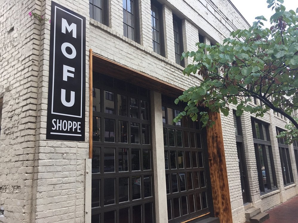 The exterior of MOFU Dumpling Shoppe, featuring a white brick facade and bold black signage.