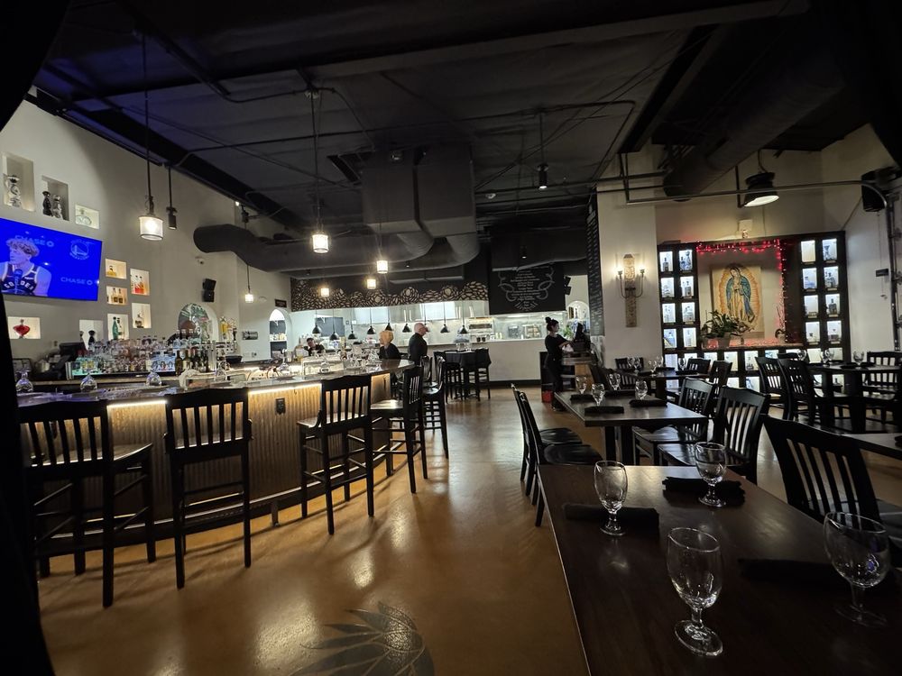 Stylish and spacious interior of Mari Chuy’s Tequileria – Rancharrah with a central bar and ambient lighting.