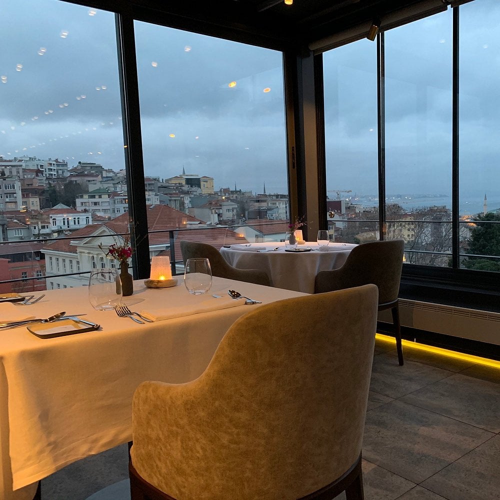 Elegant dining at Nicole Restaurant with a city and sea view.