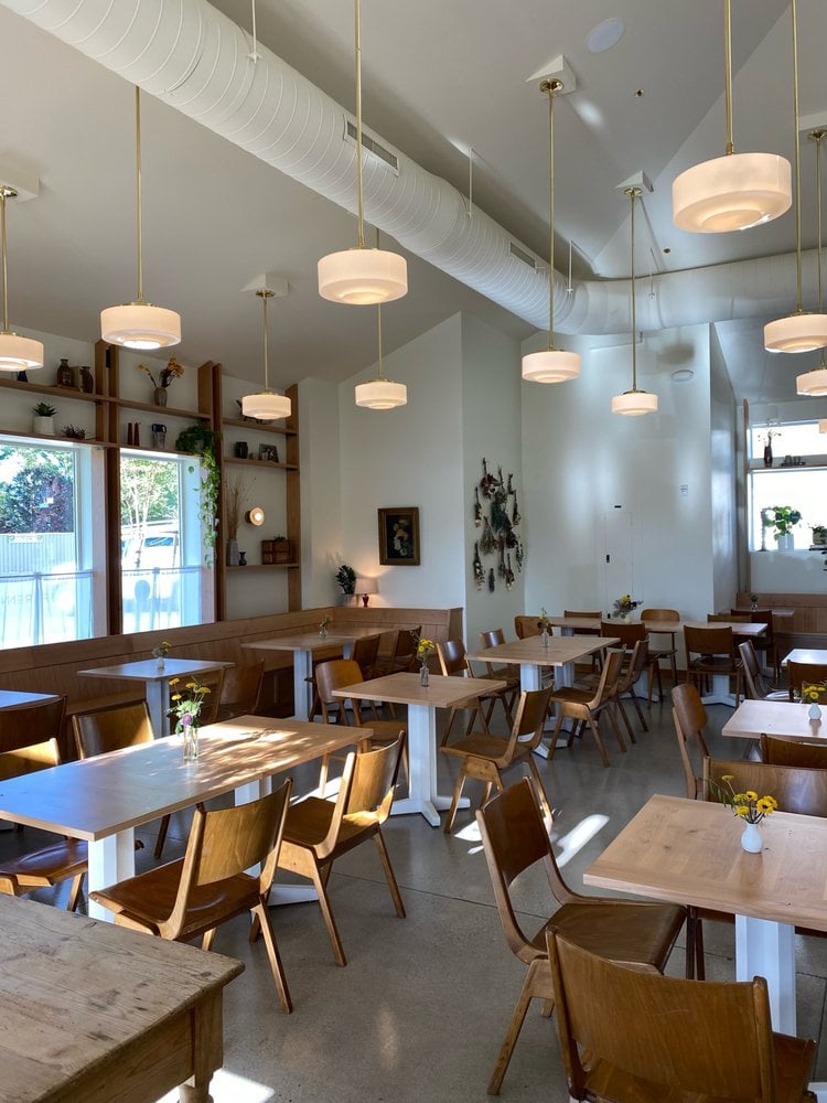 Bright and airy dining space at Perenn at Rancharrah with modern lighting and minimalist furnishings.