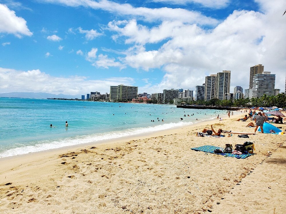 Queen's Beach with clear blue water and city skyline in the background.