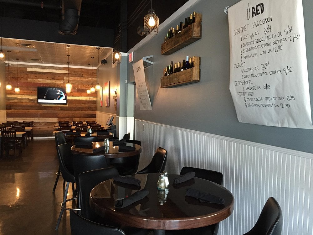 Cozy and modern setting inside Quinn's Neighbourhood Pub and Eatery with wine racks and wood accents.