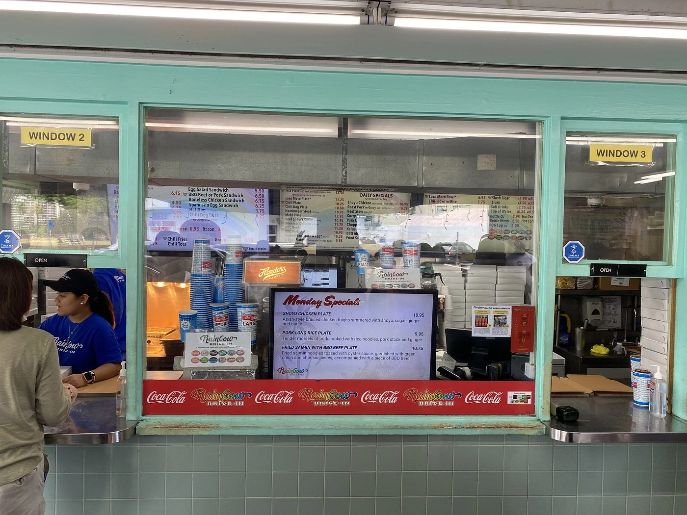 Rainbow Drive-In Oahu order windows showing classic Hawaiian drive-in restaurant with menu boards and staff preparing food