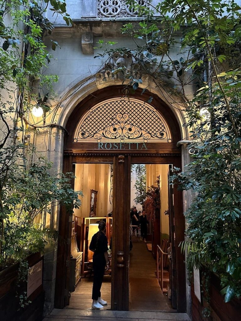 Entrance to Rosetta with lush greenery and elegant wooden doors.