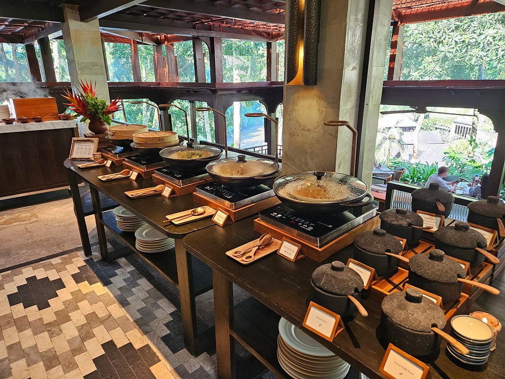 Buffet line at Sawah Terrace overlooking lush greenery with traditional Indonesian dishes.