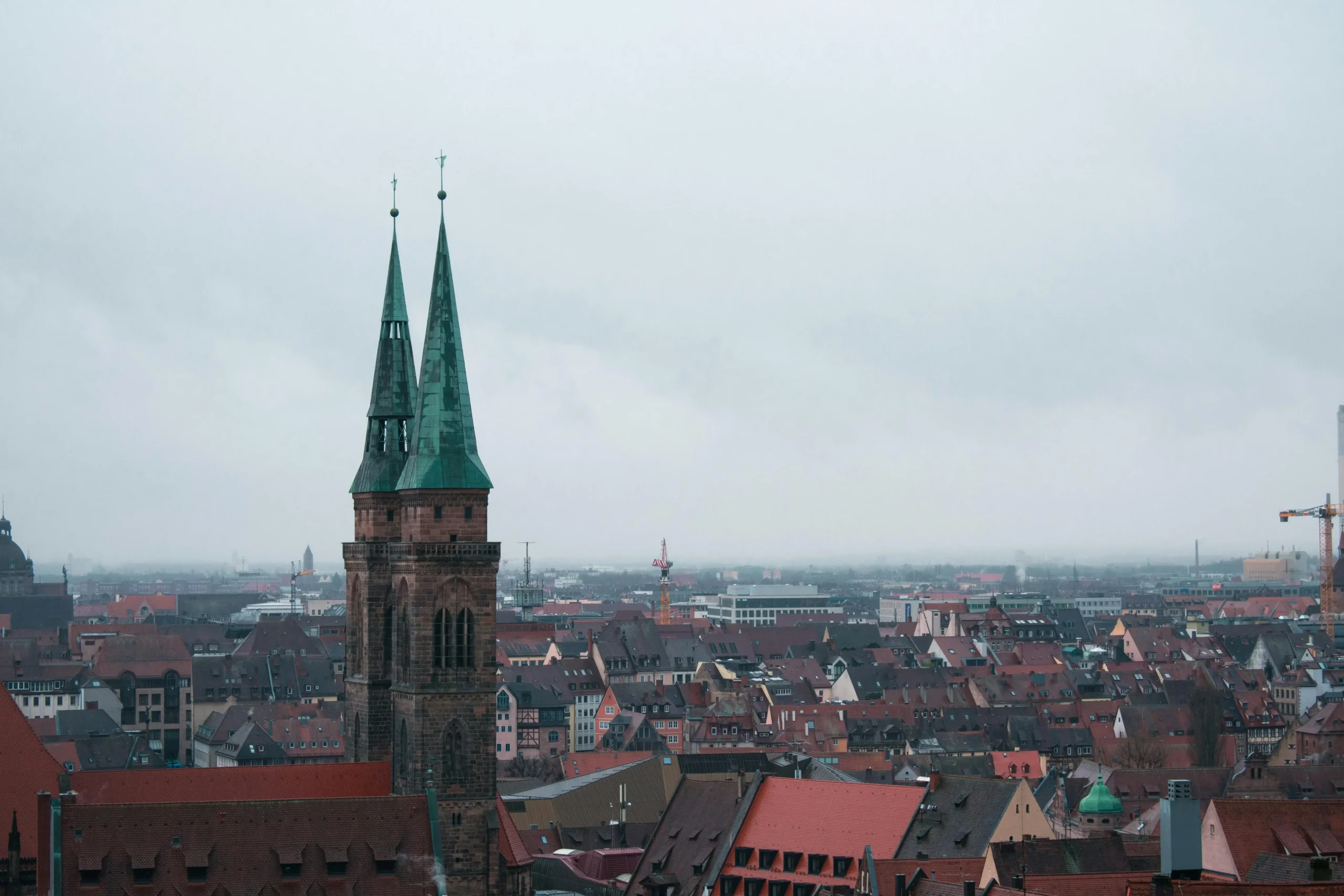 St. Sebaldus Church twin spires towering over Nuremberg's red-tiled rooftops and medieval Old Town buildings.