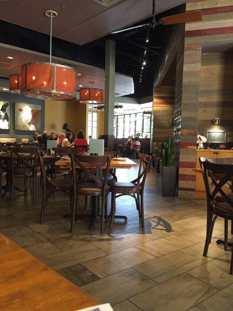 Spacious dining room at Tupelo Honey Southern Kitchen & Bar with warm lighting and rustic decor.