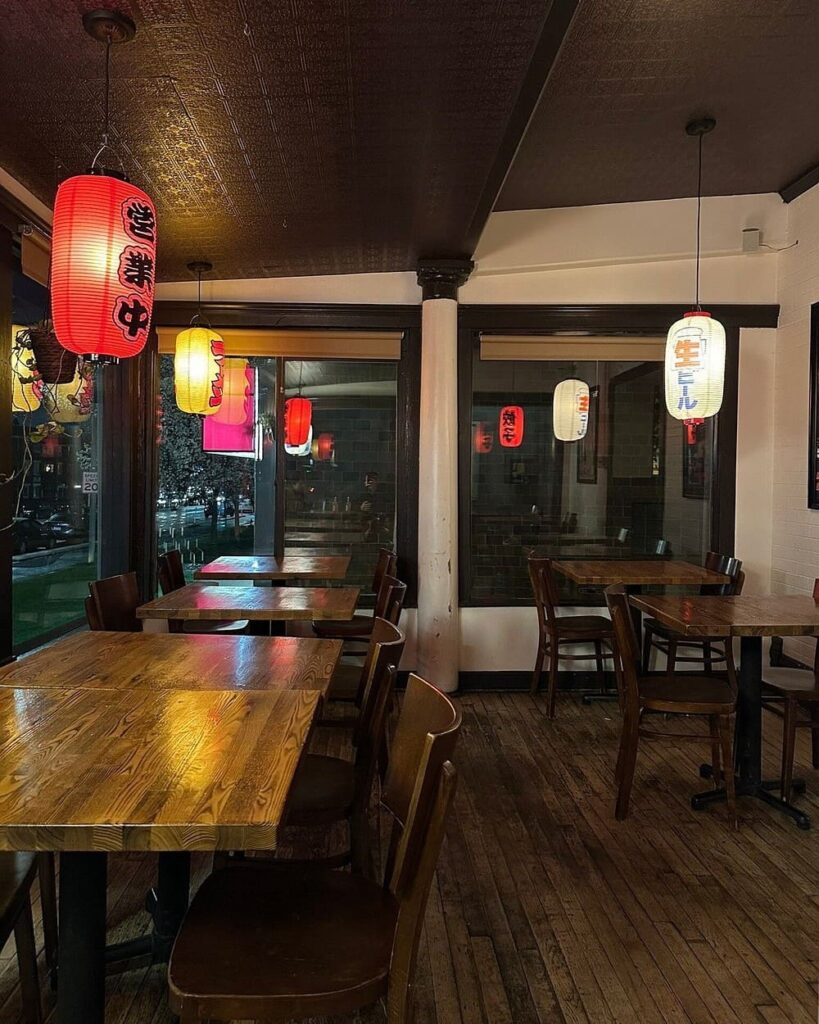 Cozy ramen shop with wooden tables and red lanterns at Yoko Ramen.