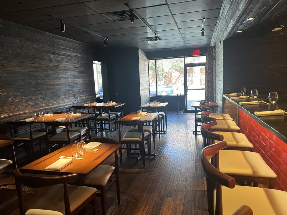 Minimalist sushi restaurant interior with modern wood furniture at Yoshitomo.