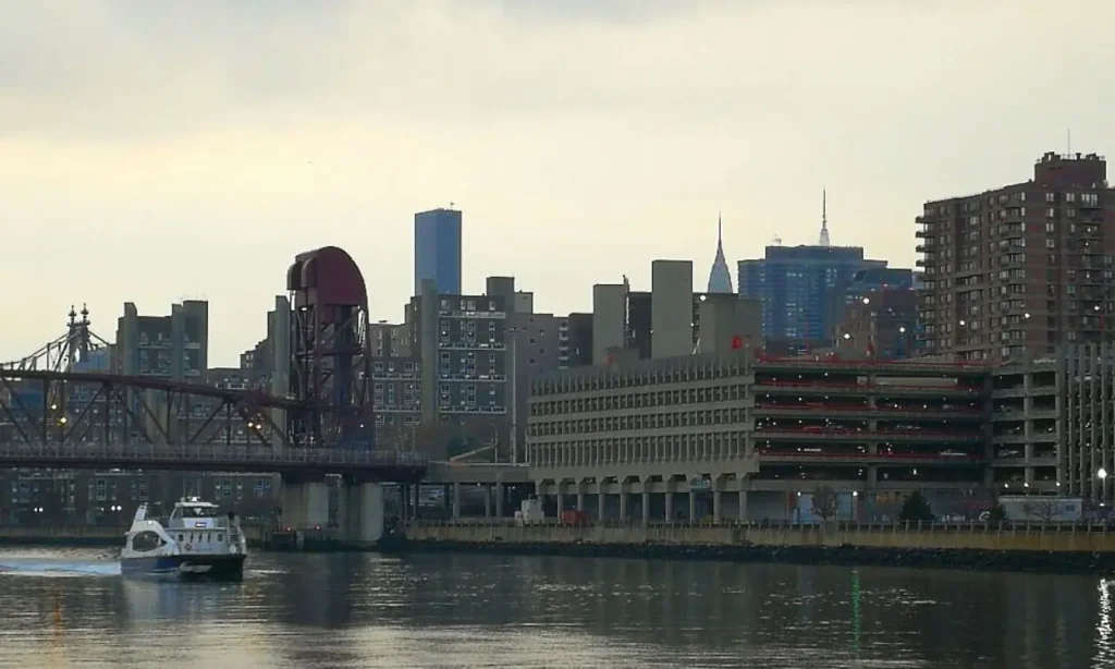 A view of the waterfront and buildings in Astoria with a boat on the water.