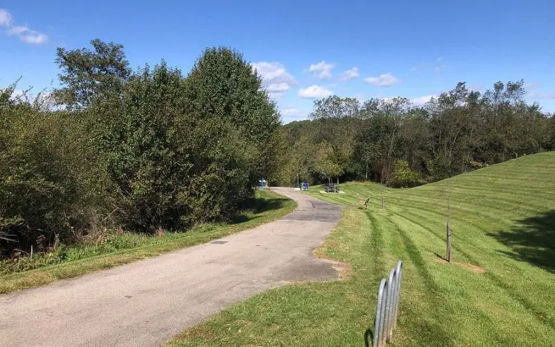 A paved path winds through greenery on the Huckleberry Trail.