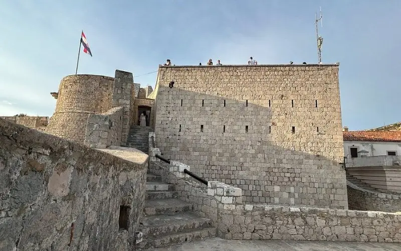 Stone walls and towers of the Hvar Fortress with a Croatian flag.