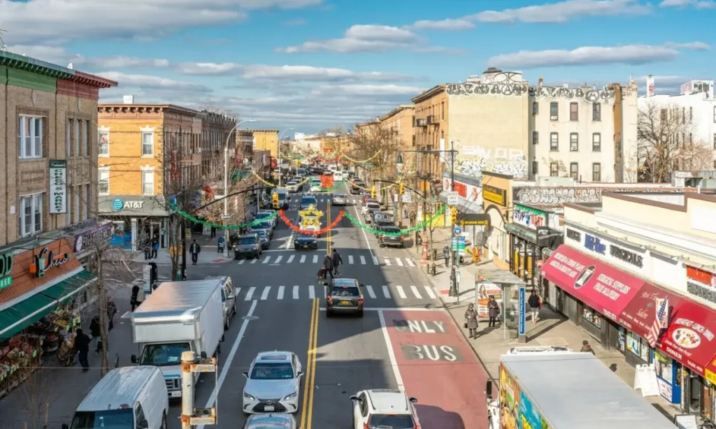 A busy street with shops, cars, and decorations in Ridgewood.