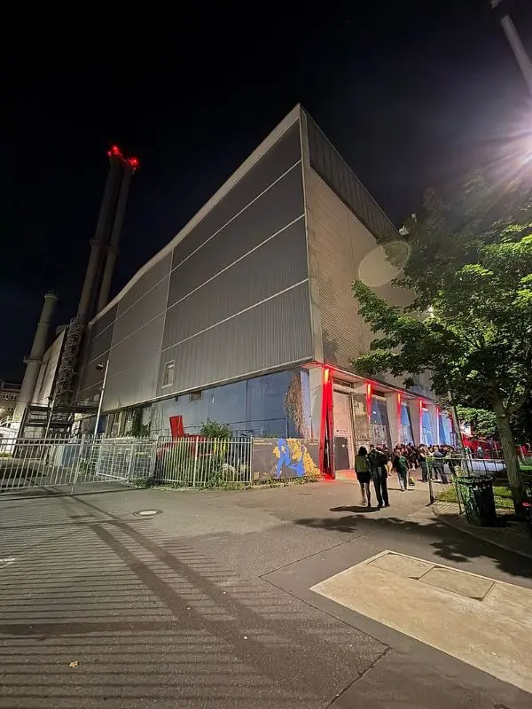The industrial exterior of Tresor nightclub glows with red lights at night.
