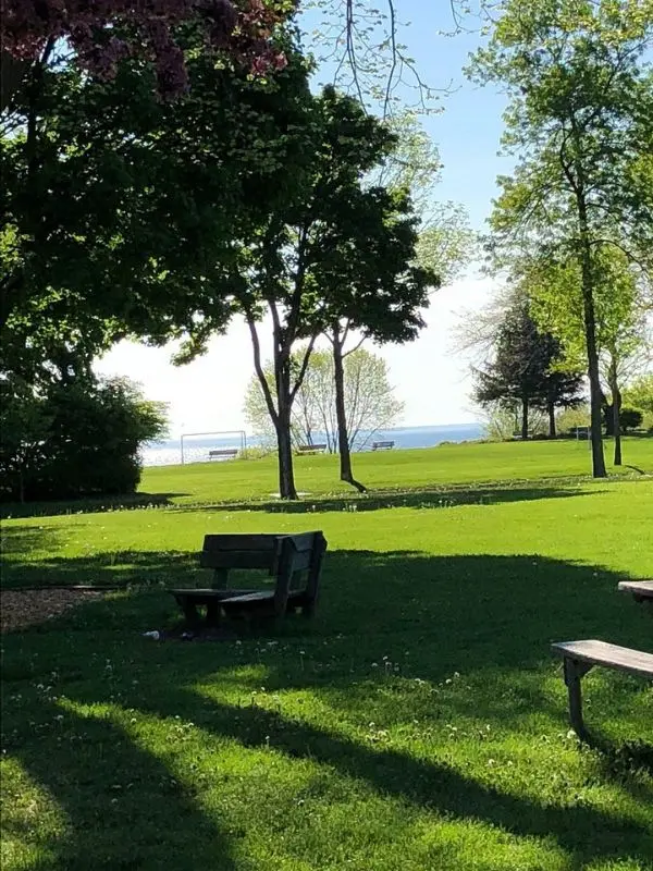 Green park with benches and a view of Lake Michigan in Whitefish Bay.