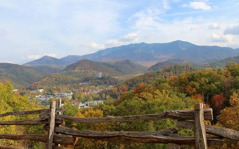 Scenic mountain view with fall colors and a wooden fence in Gatlinburg.