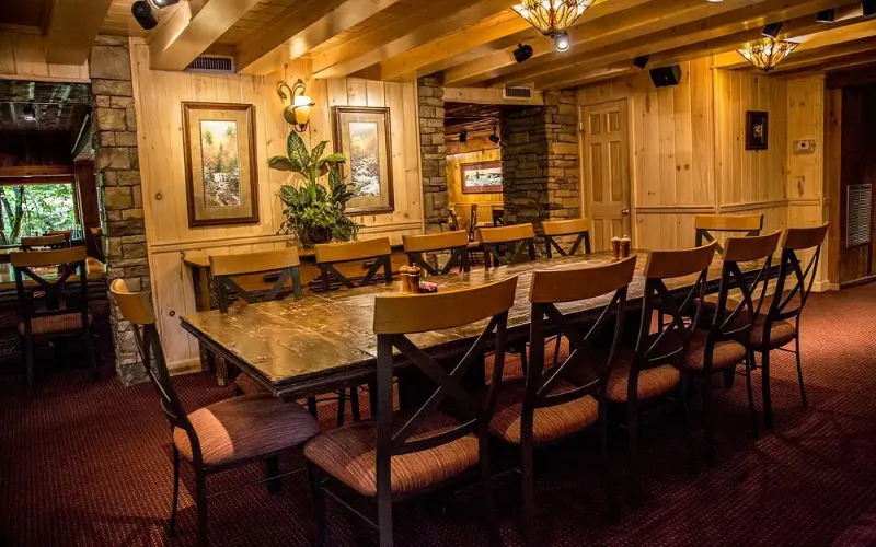 The Peddler Steakhouse features a rustic dining room with wooden beams and long tables.