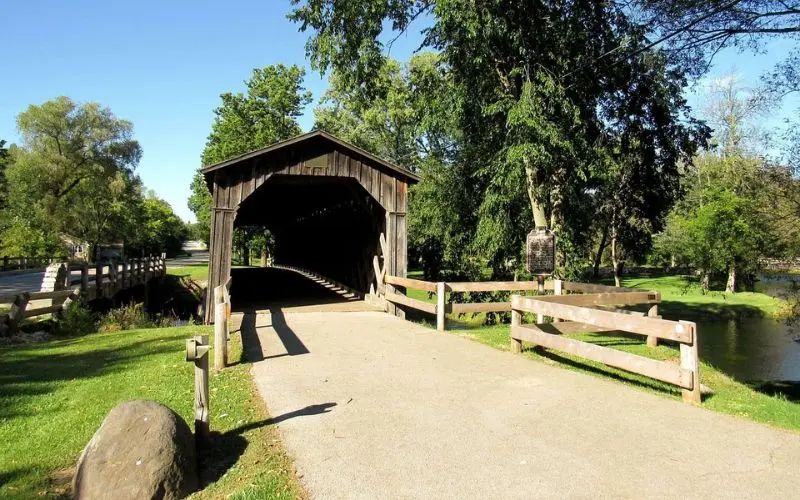 Wooden covered bridge surrounded by greenery in Cedarburg.