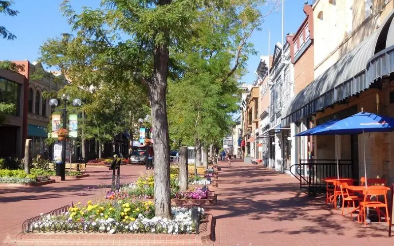 Pearl Street Mall features brick walkways, shops, and flower beds with trees.