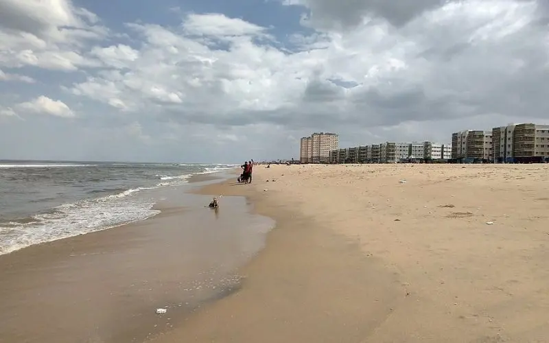 Chennai with a wide sandy beach and buildings lining the shore.