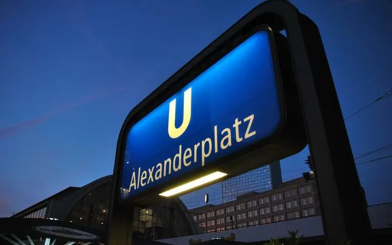 The U-Bahn sign for Alexanderplatz station glows at dusk in Berlin.