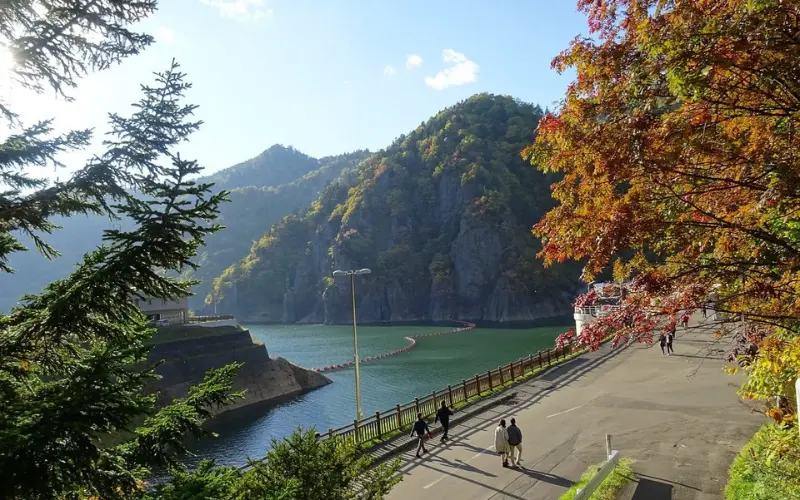Scenic view of a lake and mountains with autumn trees in Sapporo.