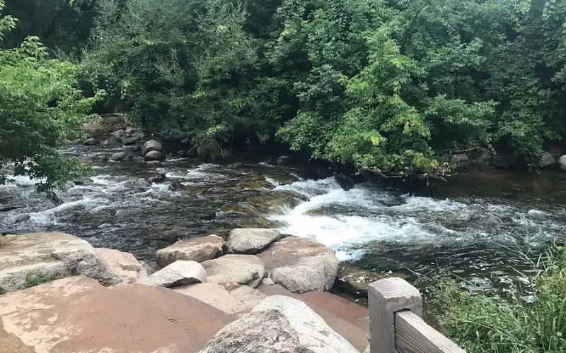 Boulder Creek Path runs alongside rushing water and trees.